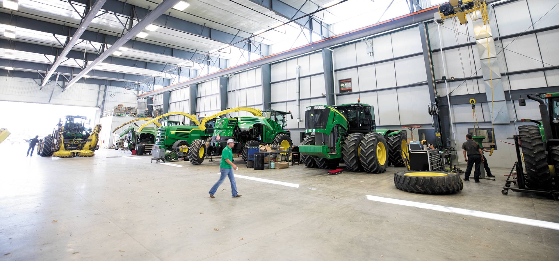 farmer walking past large John Deere tractors